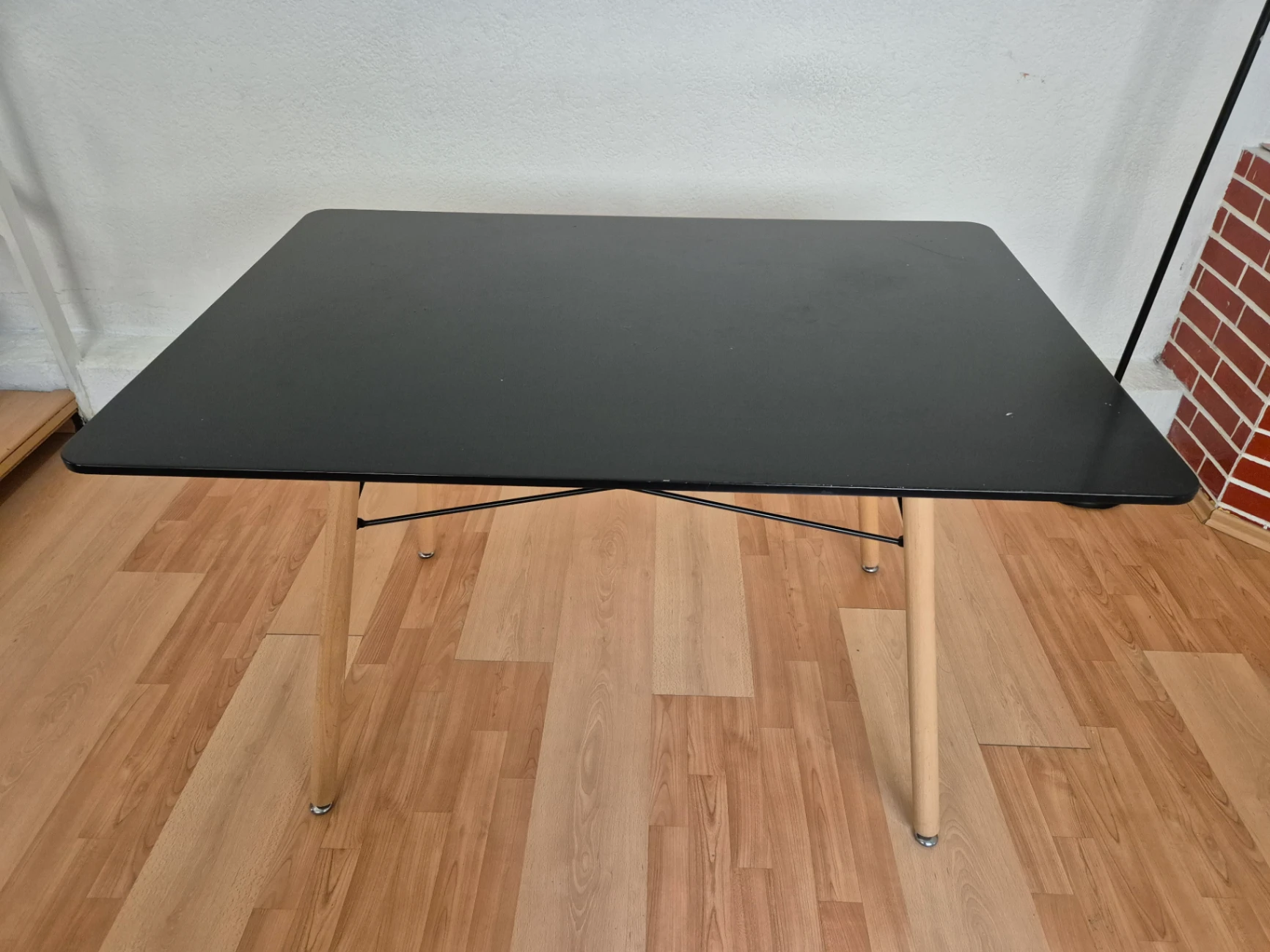 Mesa rectangular de superficie negra con patas de madera clara — foto 1